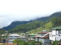 Houses built on steep hills, below terraced fields.