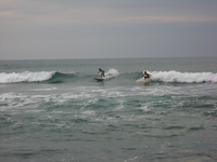 Two surfers surfing.