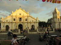 A wide, low church in white plaster, with a bell tower standing off to one side.