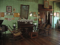 A living room with old wooden furniture and religious knick-knacks.