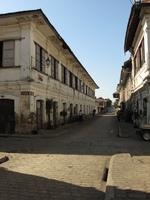 White-painted two-storey houses line both sides of a quiet, cobbled street.