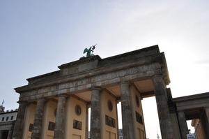 A triumphal gate in classical style against an early morning sky.