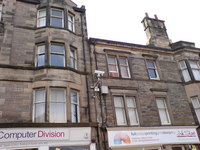 CCTV camera bolted to the side of a tenement building.