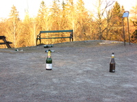 Champagne bottles and other rubbish litter the rocky ground.