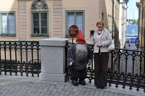 Mum standing beside a small dummy wearing a bright red hat in an old cobbled street.
